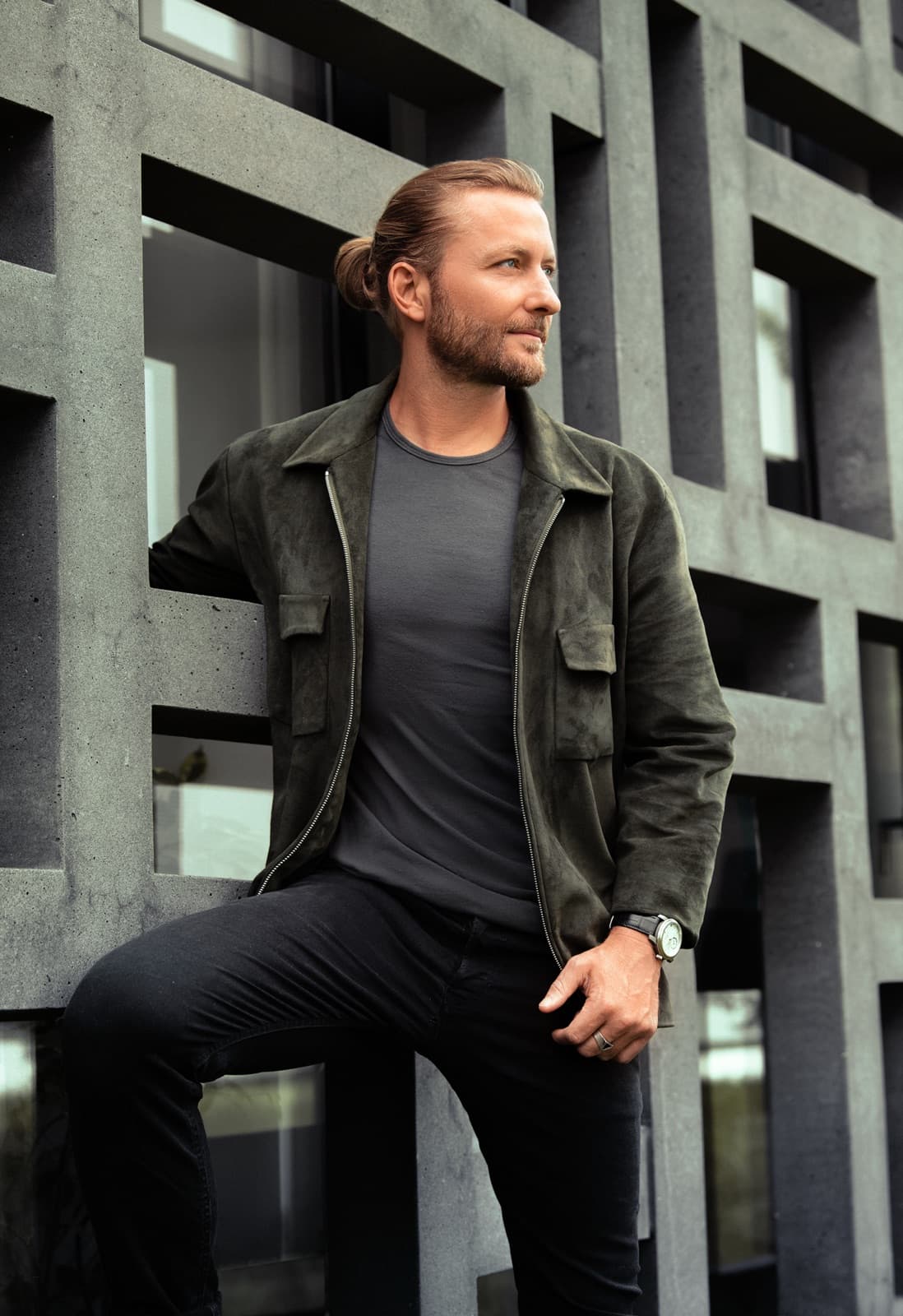 Victor Mathys in a khaki suede jacket against rectilinear architecture