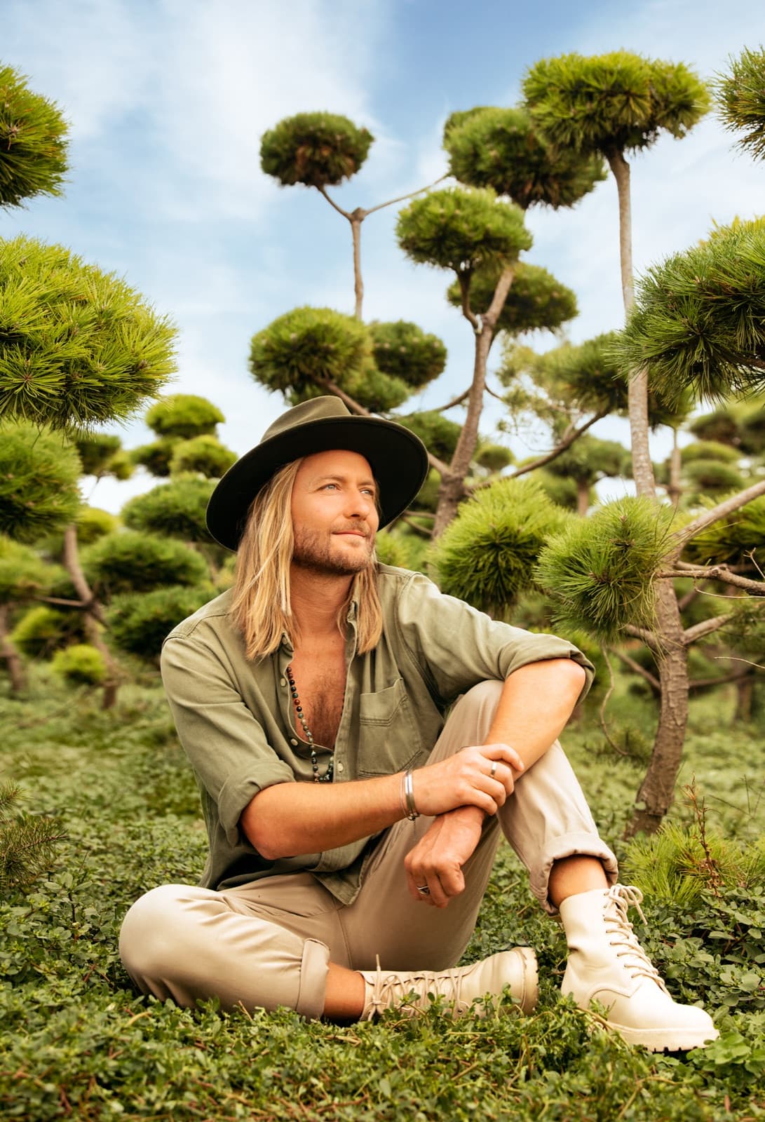 Victor Mathys outdoors beside a giant bonsai